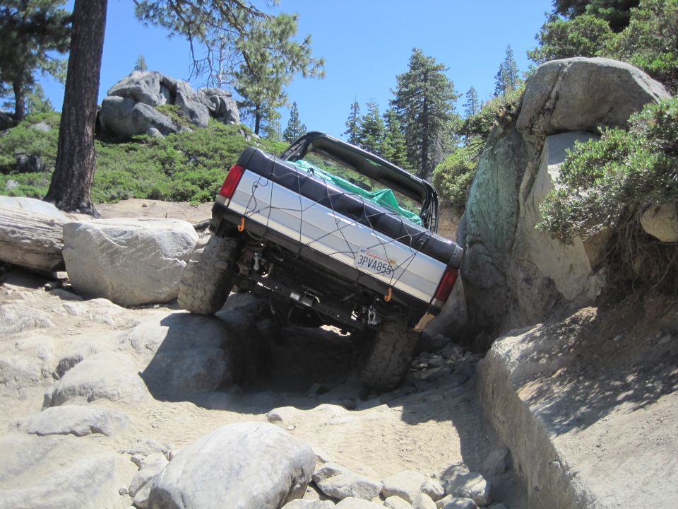 1989 Ford Bronco navigating a steep, rocky off-road trail