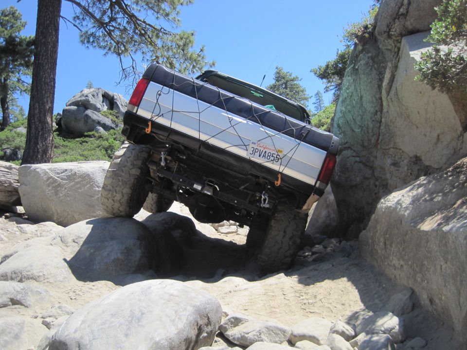 1989 Ford Bronco off-roading on rocks, California license plate 3PVA855 visible