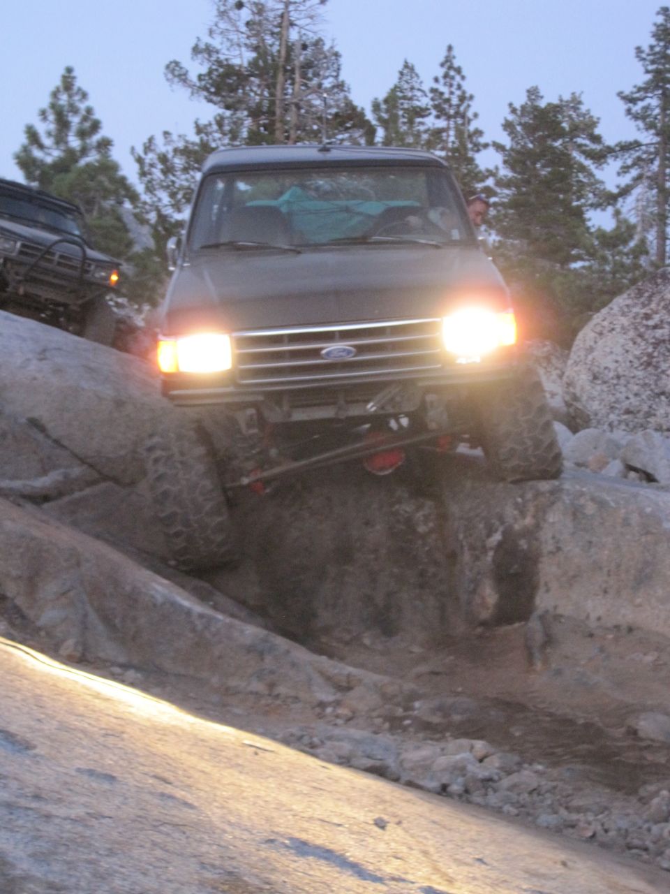 Front view of a 1989 Ford Bronco navigating rocky terrain