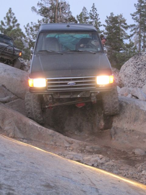 1989 Ford Bronco - 1989 Ford Bronco tackling a challenging off-road course with large boulders.