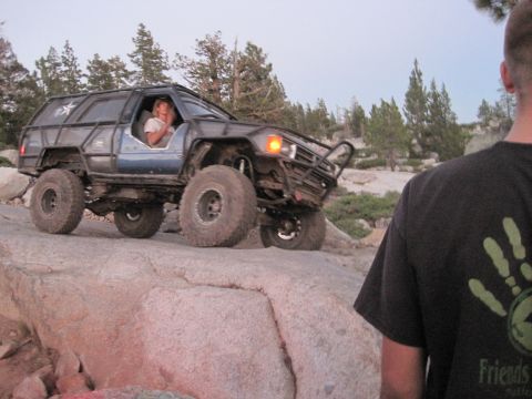 1989 Ford Bronco - A heavily modified SUV navigates a rocky trail with a person inside.