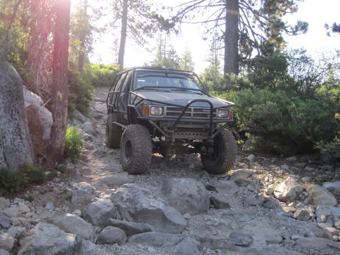 1989 Ford Bronco - This modified Toyota 4Runner navigates a challenging, rocky path through a wooded area.