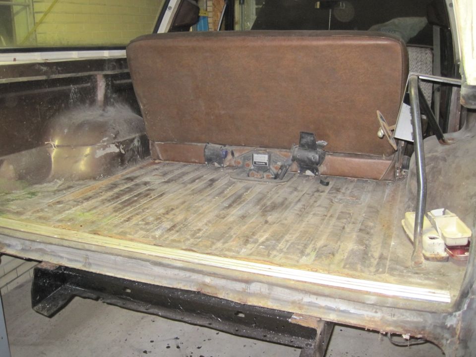 1979 Ford Bronco interior cargo area with brown bench seat and wood-paneled floor