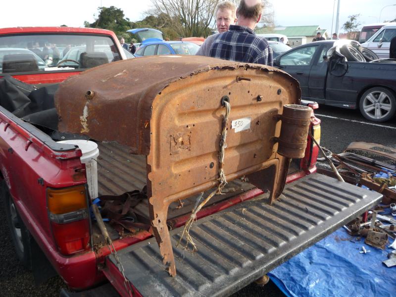 Rusted car part with '350' tag in truck bed