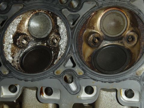 2006 Dodge Charger - Close-up of a damaged engine cylinder head, showing significant wear and carbon deposits on the valves.