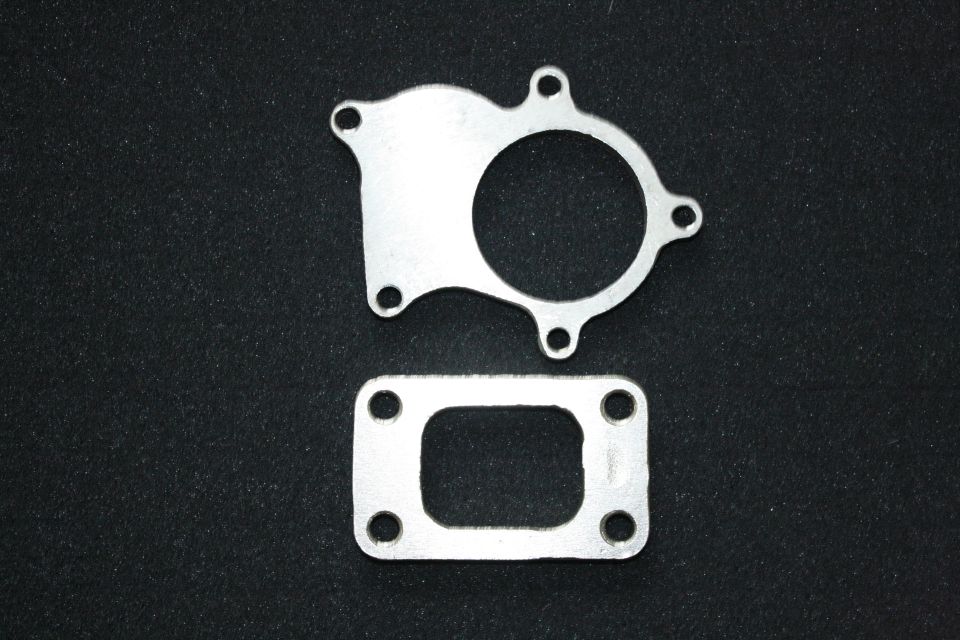 Two metal gaskets, one round and one rectangular, on black. Supermotors.net logo visible