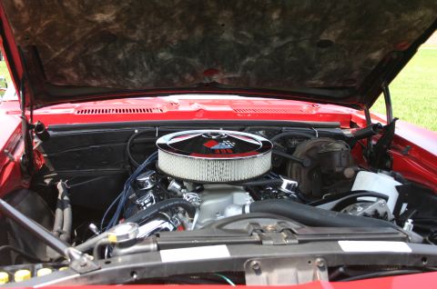 1968 Shelby GT500 - The engine bay of a red 1969 Chevrolet Camaro is visible, a 396 cubic inch engine.