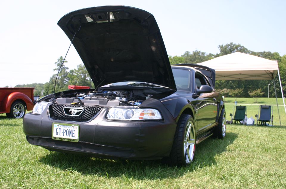 Black Ford Mustang with hood open, showing engine and custom plate GT-PONE