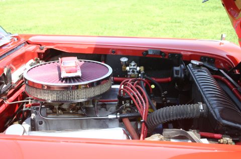 1968 Shelby GT500 - The engine bay of a red car is visible, a large air filter with a toy car placed on top.
