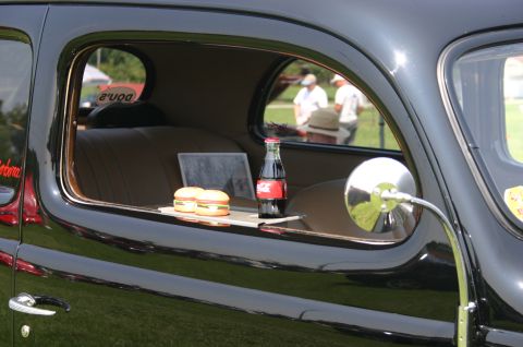 1968 Shelby GT500 - A vintage car's interior is set up with a meal, including burgers and a soda, for display.