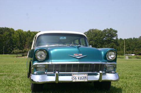 1968 Shelby GT500 - A 1956 Chevrolet station wagon is parked on a grassy field with trees in the background.