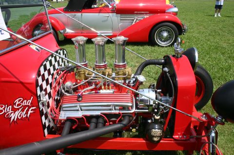 1968 Shelby GT500 - A custom hot rod with a prominent engine and "Big Bad Wolf" graphics sits on display next to another classic car.