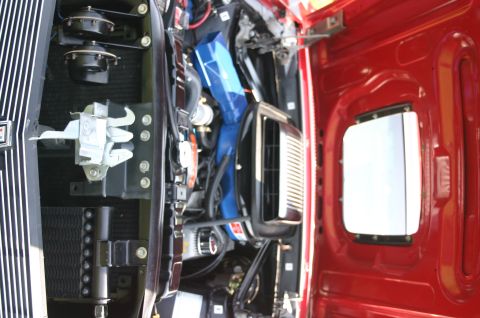 1968 Shelby GT500 - The engine bay of a red vehicle is visible, blue intake components and various engine parts.