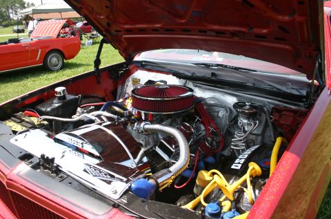 1968 Shelby GT500 - The engine bay is heavily customized with chrome parts and a prominent red air filter. A second vehicle is visible in the background.