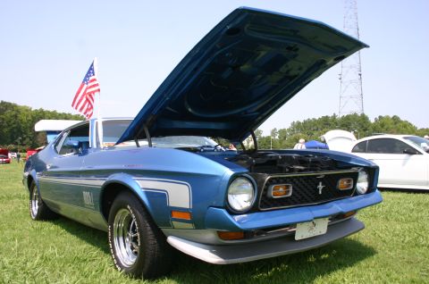 1968 Shelby GT500 - A blue 1971 Ford Mustang Mach 1 is displayed with its hood up at an outdoor event.
