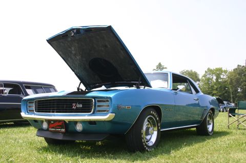 1968 Shelby GT500 - A blue 1969 Chevrolet Camaro Z/28 is displayed with its hood open at an outdoor car show.