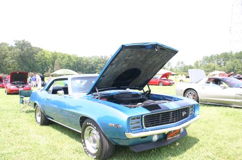 1968 Shelby GT500 - A blue 1969 Chevrolet Camaro is displayed with its hood open at an outdoor car show.