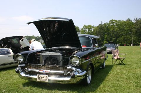 1968 Shelby GT500 - A black 1957 Chevrolet station wagon is displayed with its hood open at an outdoor car show.