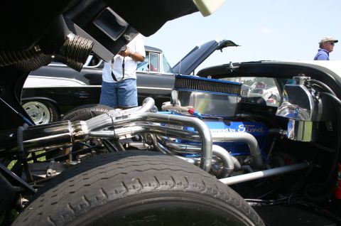 1968 Shelby GT500 - Custom Ford V8 engine with headers and air intake, seen at a car show with other vehicles present.