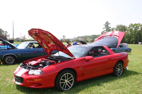 1968 Shelby GT500 - A red sports car is displayed with its hood open at an outdoor car show.