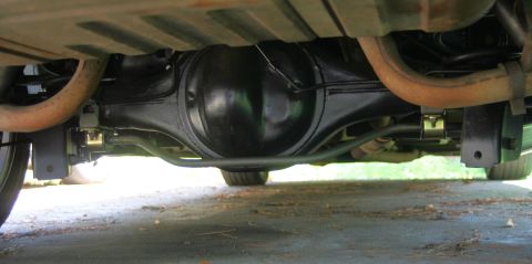 1976 Ford Ranchero - Underside view of a vehicle's rear axle and suspension system, showing the differential and exhaust pipes.
