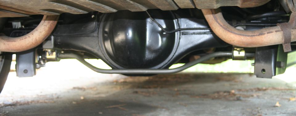 Rear axle and suspension components with exhaust pipes visible