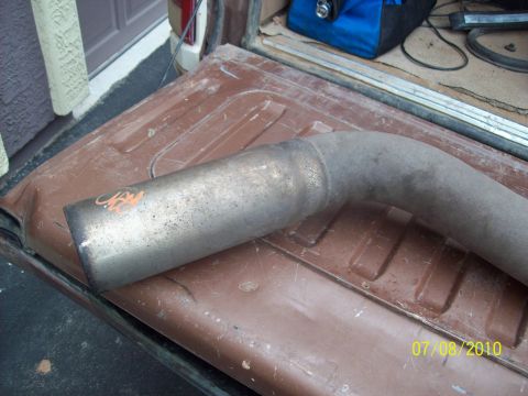 1985 Ford Bronco - An exhaust pipe is placed on the bed of a truck, with visible orange markings and a date stamp in the corner.