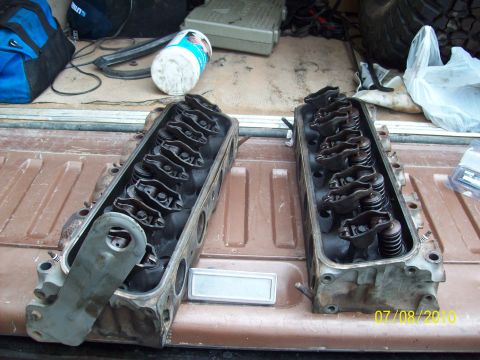 1985 Ford Bronco - Two engine cylinder heads are laid out, showing their internal components like rocker arms and springs.