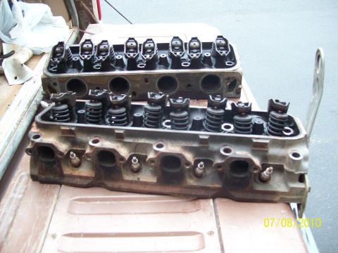 1985 Ford Bronco - Close-up of two engine cylinder heads, showing internal components like rocker arms and valve springs.