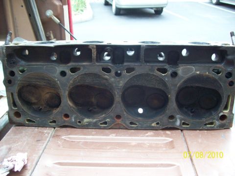1985 Ford Bronco - Close-up of an engine cylinder head, showing the internal combustion chambers and valve seats.