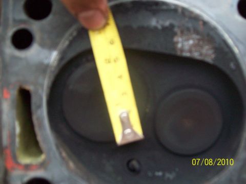 1985 Ford Bronco - Measuring the valve opening on an engine cylinder head with a yellow tape measure.