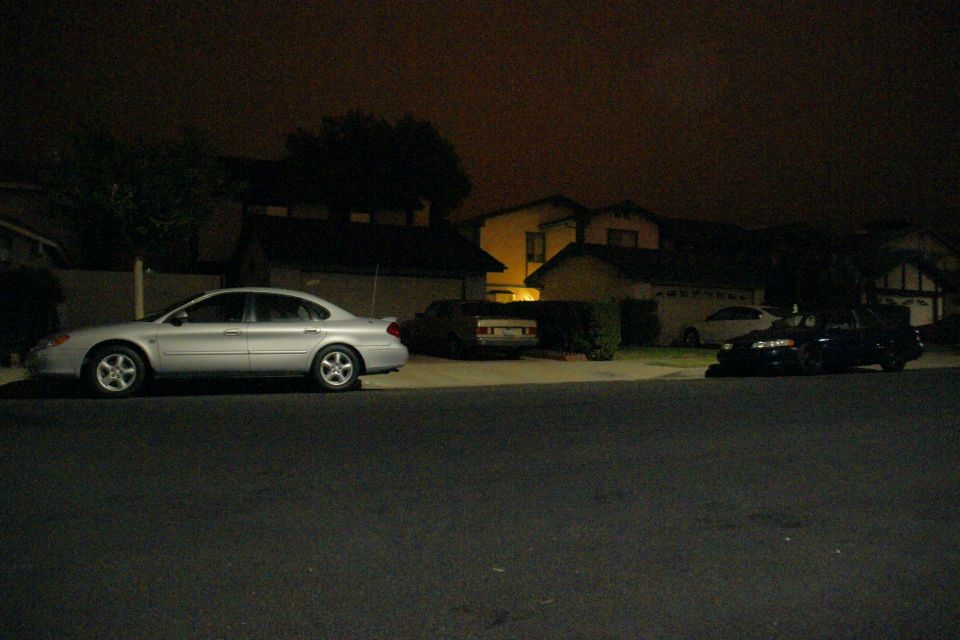 Silver sedan, side view, circa 2000. Another car is parked in the background