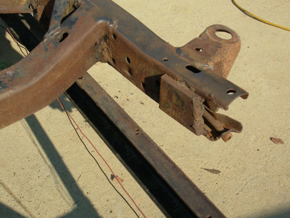 Rusted truck frame crossmember and bracket on concrete