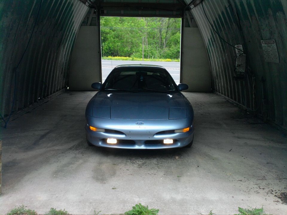 Blue 1994 Ford Probe parked inside a Quonset hut garage