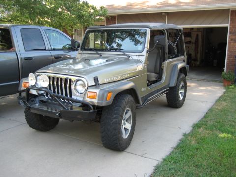2005 Jeep Wrangler - A silver 2005 Jeep Wrangler Rubicon is parked in a driveway with its doors removed.