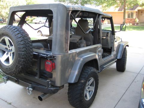 2005 Jeep Wrangler - This 2005 Jeep Wrangler is shown from the rear three-quarter view, highlighting its lifted stance and off-road tires.