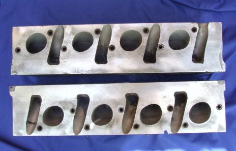 1973 Ford Mustang - Two aluminum engine cylinder heads are shown, with faint text visible on the top one reading 'ALLEN ARD CO'.