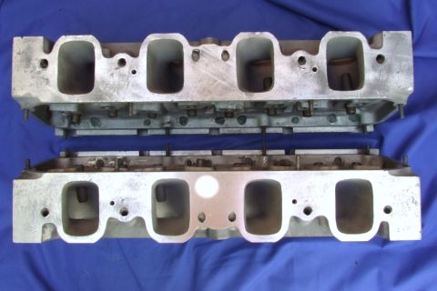 1973 Ford Mustang - Two aluminum V8 engine cylinder heads are shown against a blue cloth background.