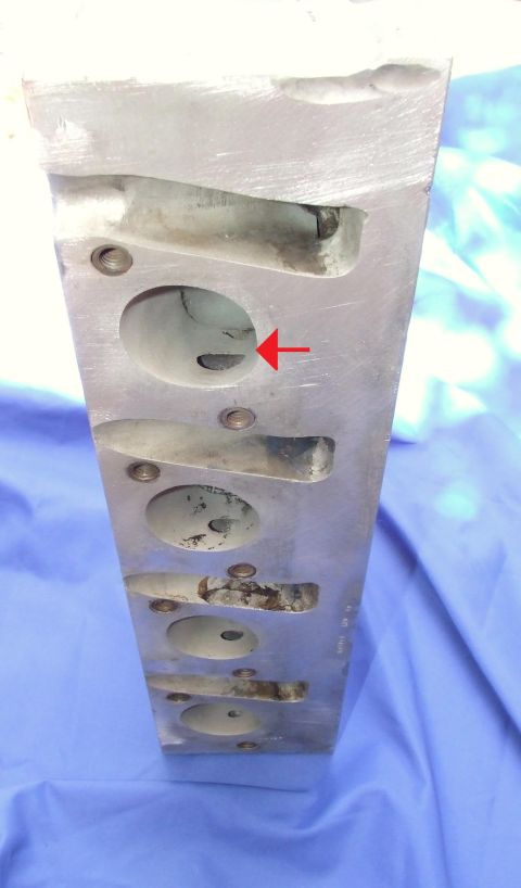 1973 Ford Mustang - Close-up of an engine cylinder head, showing its internal structure and a directional arrow.