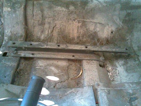 1972 Ford Ranchero - Interior view of a vehicle's floor pan, showing seat mounting hardware and accumulated dirt.