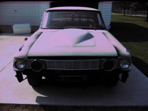 1992 Ford Mustang - Front view of a 1964 Ford Fairlane with a prominent hood scoop, parked in front of a garage.