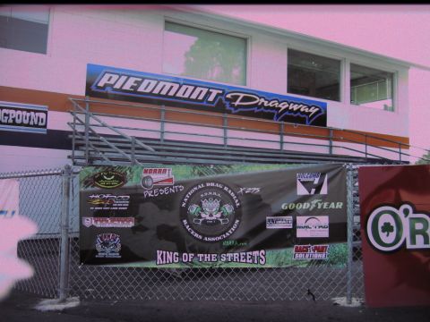 1992 Ford Mustang - Banners hang on a fence at Piedmont Dragway, advertising NDRRA X275 King of the Streets.