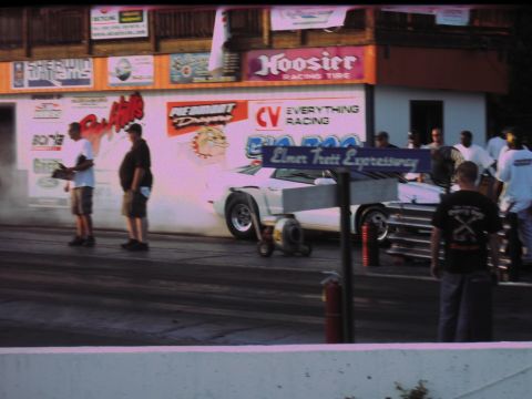 1992 Ford Mustang - A white 1992 Ford Mustang drag car is seen on the track, emitting smoke from its tires.