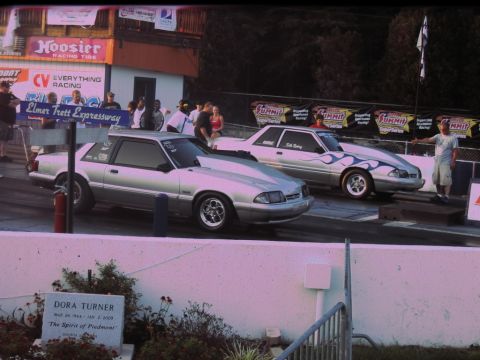 1992 Ford Mustang - Two silver Ford Mustangs prepare for a drag race, one blue flame decals.
