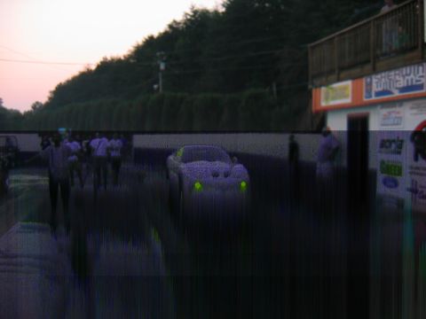 1992 Ford Mustang - A car with glowing green headlights sits on a drag strip at dusk.