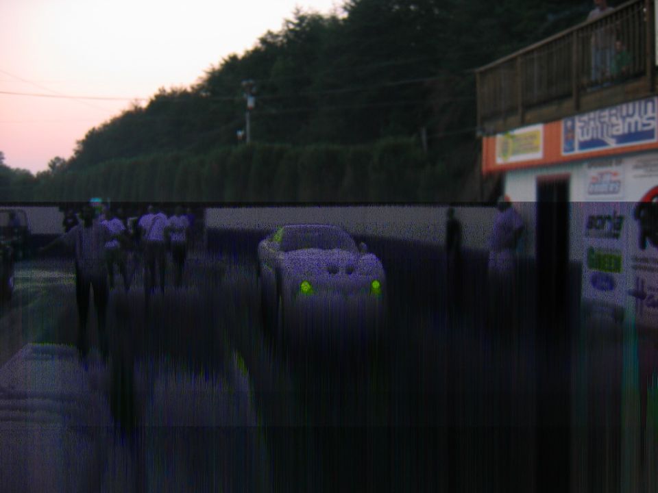 purple car with green headlights at drag strip