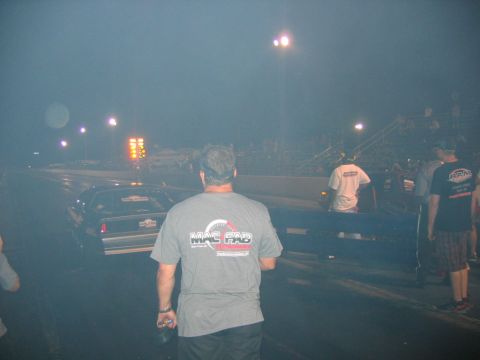 1992 Ford Mustang - Night drag race with a car on the track and spectators watching from the stands.