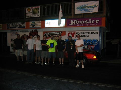 1992 Ford Mustang - A group of people stand with a red 1994 Ford Mustang at a racing event.