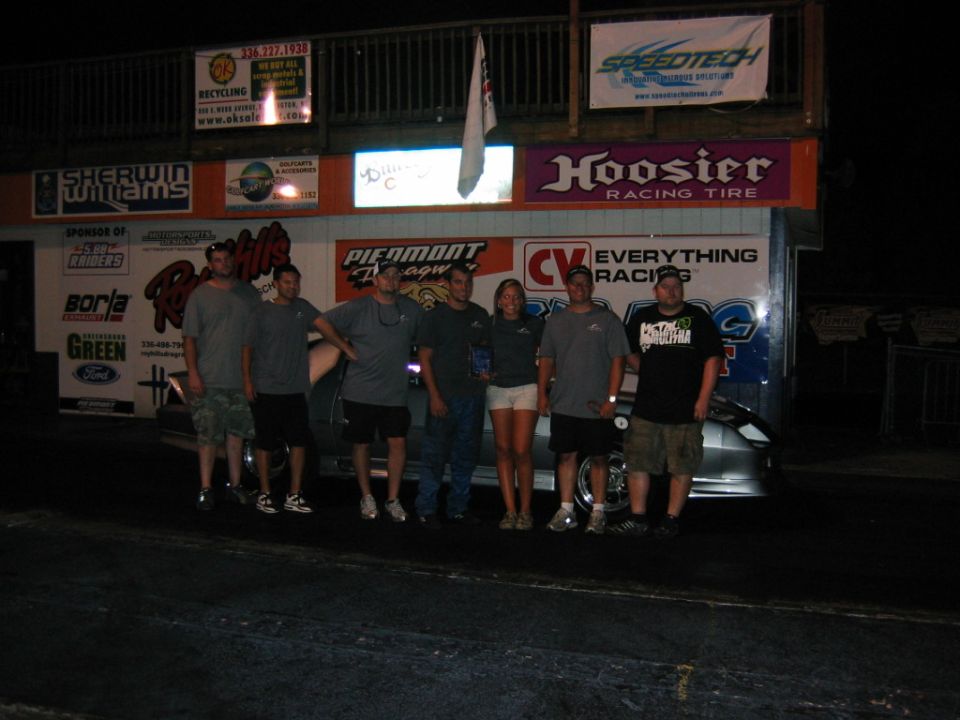 Group of people in front of a building with racing advertisements