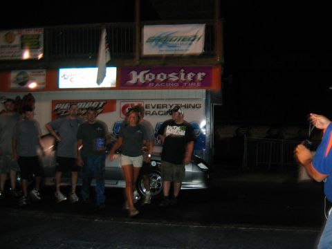 1992 Ford Mustang - Spectators gather at a nighttime racing event, with prominent signage for Hoosier Racing Tire and Speedtech.